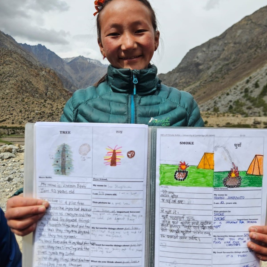 A child from Limi Valley in Nepal, showing her drawings from an ABC workshop. 