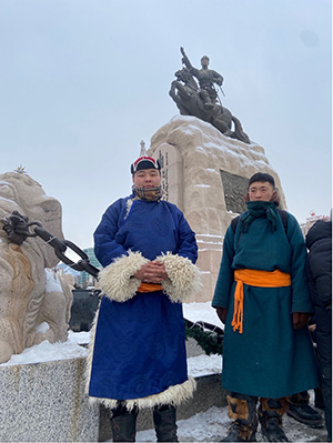 A protestor stands in front of Sükhbaatar's statue