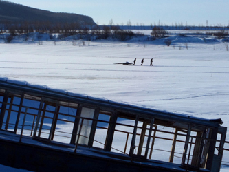 Fishermen pull a sled stacked with firewood past a marooned tourist pleasure boat in the Hezhe village Jiejinkou, China (Ed Pulford, 2014)