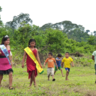 Shuar girls readying for a beauty queen competition which prepares them for the future, accompanied by children ready to play football, another important index of the future