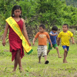 Shuar girls readying for a beauty queen competition which prepares them for the future, accompanied by children ready to play football, another important index of the future