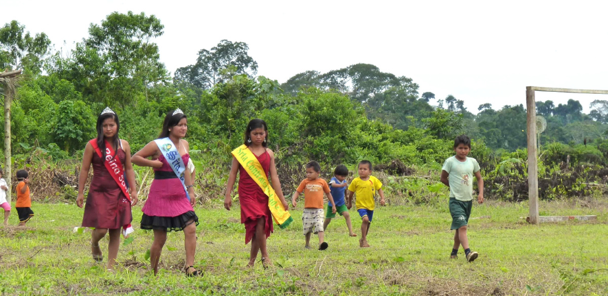 Shuar girls readying for a beauty queen competition which prepares them for the future, accompanied by children ready to play football, another important index of the future, 2012. Shuar girls readying for a beauty queen competition which prepares them for the future, accompanied by children ready to play football, another important index of the future