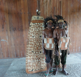 Tourists: Mbes and Serambi, from the village of Er, ask to have their photo taken dressed up as ‘people from Jakapis’ while visiting that village, having found items of self-decoration stored in the local Church (Tom Powell Davies, 2016)